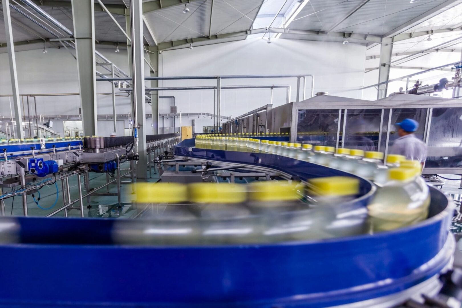 A conveyor belt with many yellow cans on it.