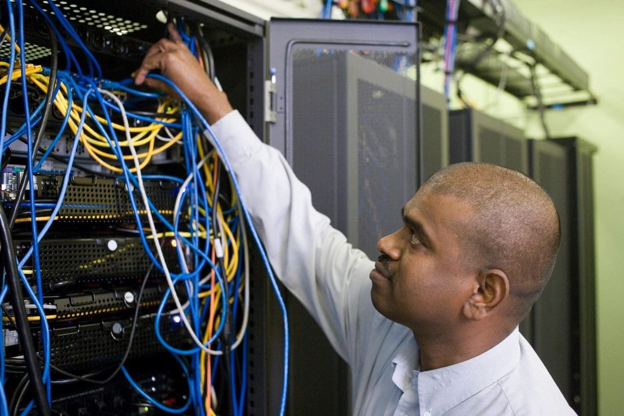 A man working on wires in an office.